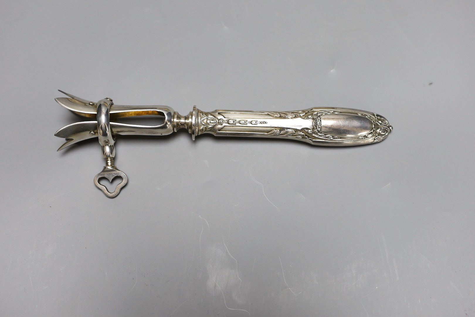 A silver plated ham clamp, cased, 21 cms long.